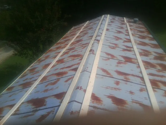 Rusted metal roof panels with new wood purlins before replacement — Storm Damage Roof Repair in Mc Causland by Roofing Brothers