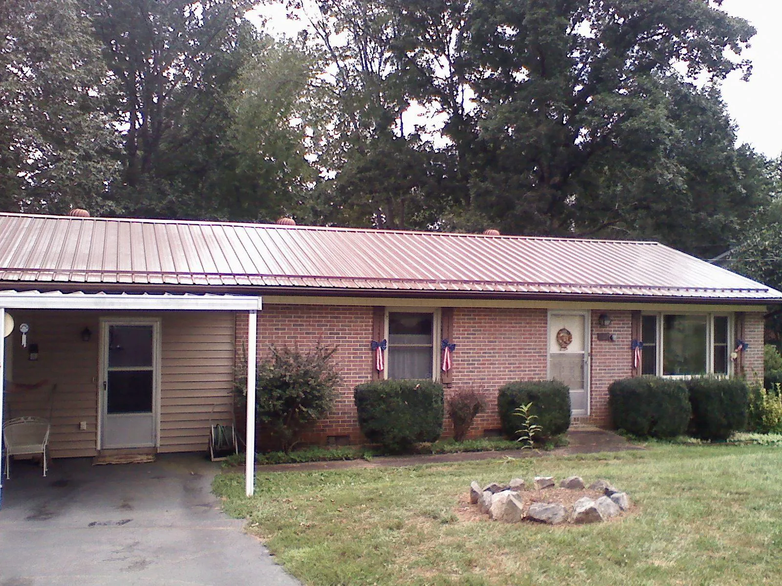 Bronze metal roof and carport on a brick ranch home — Roof Repair work by our crew in Mc Causland